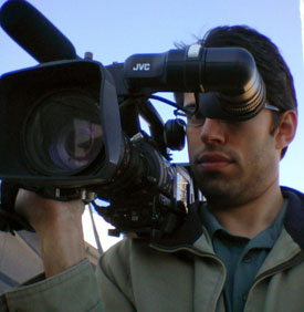 David S Waxman stands with a shoulder-mount Pro HD camcorder